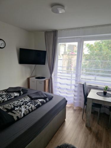 a bedroom with a bed and a table and a window at M&BLuxux Apartaments in Krefeld