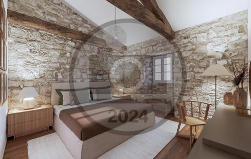 um quarto com uma cama e uma parede de pedra em Nice Home In Buzet With Kitchen em Buzet