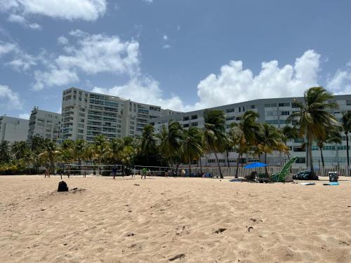 a beach with palm trees and a large building at Ismael in San Juan