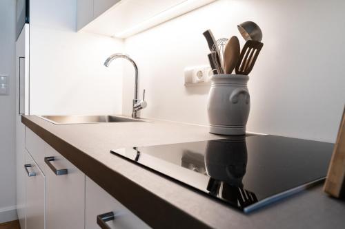 eine Küchentheke mit einem Messerhalter und Küchenutensilien in der Unterkunft twenty five - work & life Apartments in Amstetten