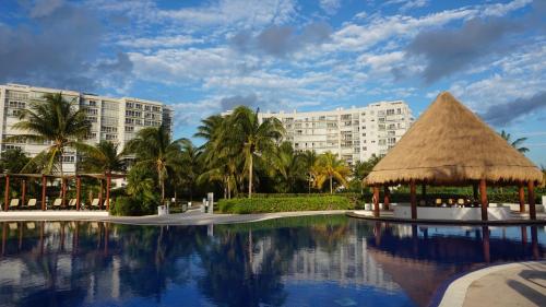 a resort with a swimming pool and a large building at Well equipped condo with splendid sea view in Cancún