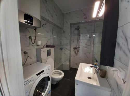 a bathroom with a washing machine and a sink at Bella Luxury Suite III in Paralia Katerinis