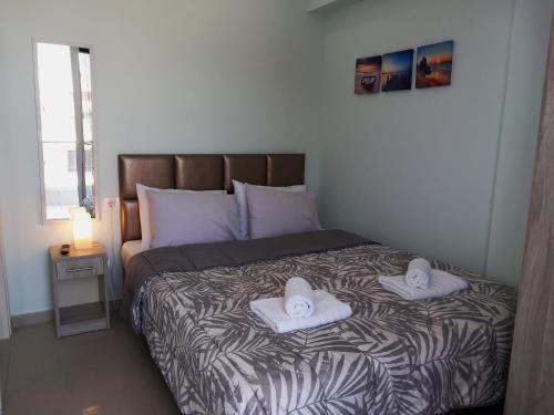 a bedroom with a bed with two towels on it at Bella Luxury Suite III in Paralia Katerinis