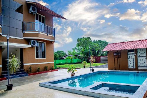 uma piscina em frente a uma casa em Seasons The Resort em Alibag