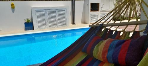 a hammock in front of a swimming pool at Suite - Recanto da Lima - com entrada independente in Setúbal