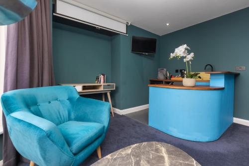 Cette chambre bleue comprend une chaise bleue et un bureau. dans l'établissement ART B&B, à Blackpool