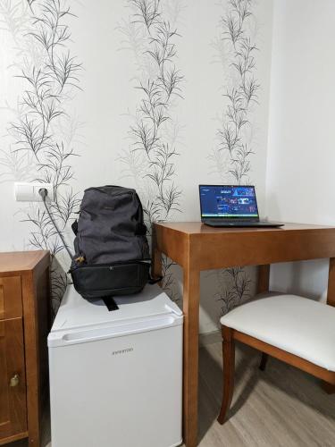 a laptop computer sitting on top of a refrigerator next to a desk at H. O Lar in O Barco de Valdeorras