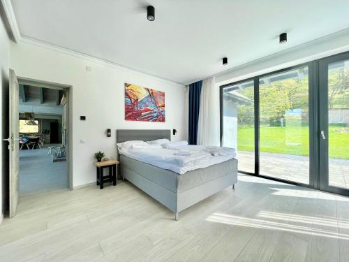 ein Schlafzimmer mit einem Bett und einem großen Fenster in der Unterkunft KissHaz in Sovata