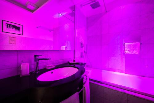 Baño rosa con lavabo y espejo en Mascherino Suites, en Roma