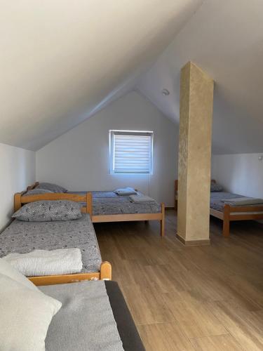 a room with three beds and a window at Vikendica na dan in Novi Sad