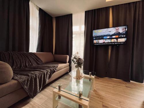 a living room with a couch and a flat screen tv at Altstadt Hotel Schwanen in Waldshut-Tiengen