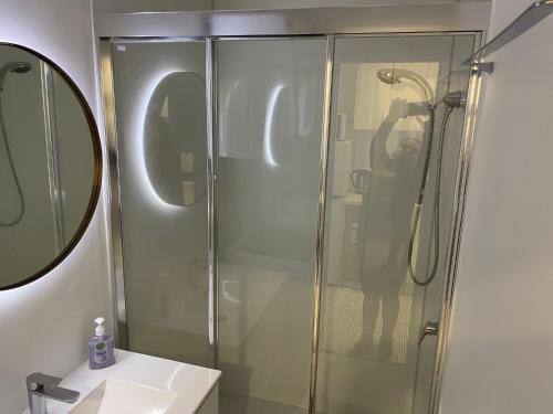 un homme prenant une photo d'une douche dans une salle de bains dans l'établissement Cozy Room Next to Bond University, à Gold Coast