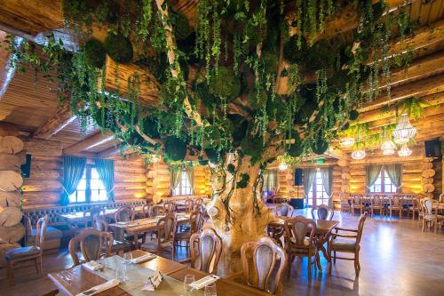 a large tree in a restaurant with tables and chairs at HANU VISOIANU in Lunca Cetăţuii