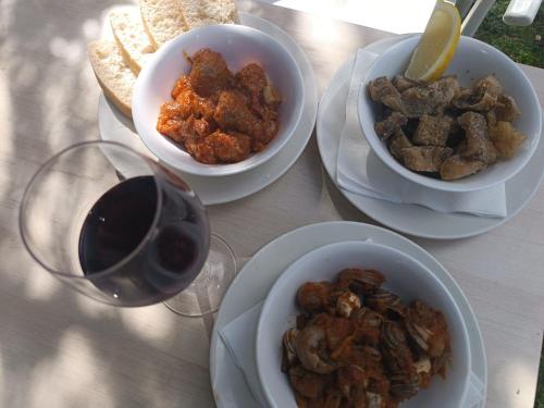 a table with plates of food and a glass of wine at Alberg - Restaurant Vall Fosca in Torre de Capdella