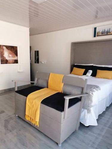 a bedroom with a bed with a yellow blanket on it at Ticia Apartment in Chipata