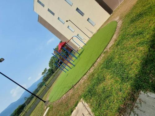 un bâtiment avec une clôture à côté d'un champ vert dans l'établissement Apartamento en condominio con piscina, à Villavicencio