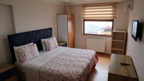 Habitación pequeña con cama y ventana en Akustik Residence en Bostancı