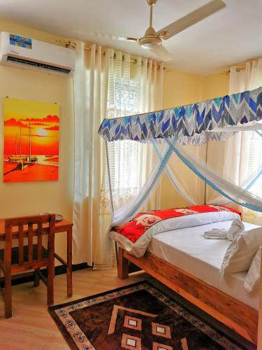 a bedroom with a bed with a canopy at Sinthia Hotel Apartments in Chaki Chaki