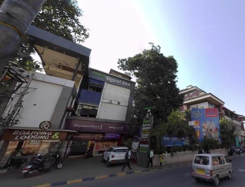 una concurrida calle de la ciudad con coches aparcados en la calle en Hotel Royal Inn Mangalore - Opp SDM Law College MG Road, en Mangalore