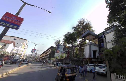 eine belebte Stadtstraße mit Autos und Menschen auf dem Bürgersteig in der Unterkunft Hotel Royal Inn Mangalore - Opp SDM Law College MG Road in Mangaluru