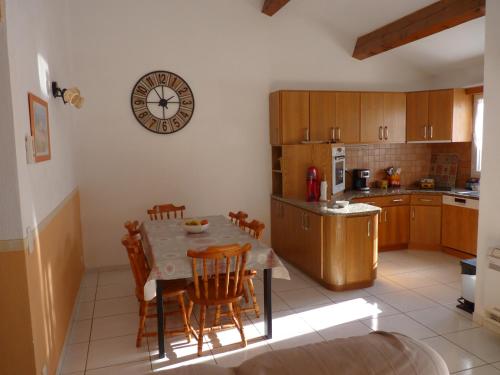 une cuisine avec une table et des chaises et une horloge au mur dans l'établissement VILLA DANIELA, à Vias