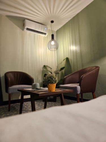 a room with two chairs and a table with a plant at 85 Boutique Hotel in Ipoh