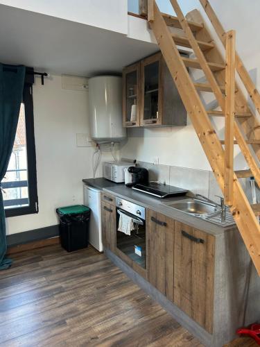 une cuisine avec un évier et une cuisinière four supérieur dans l'établissement Le Duplex Chaleureux à Disneyland, à Montry
