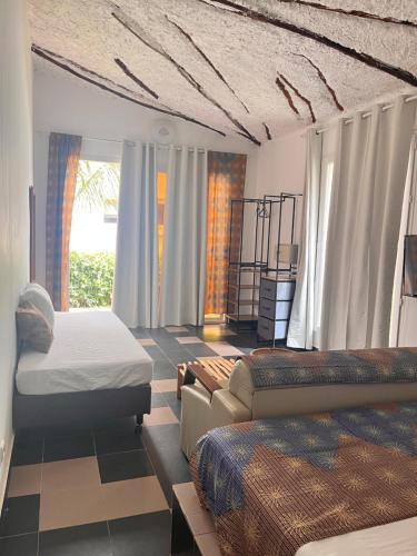 a bedroom with two beds and a couch at Keur Ama in Mbour