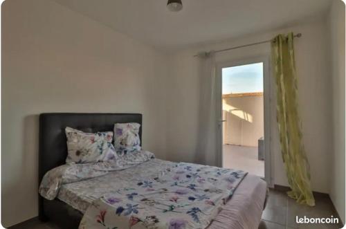 une chambre avec un lit et une porte coulissante en verre dans l'établissement Maison de l’occitanie, à Bessan