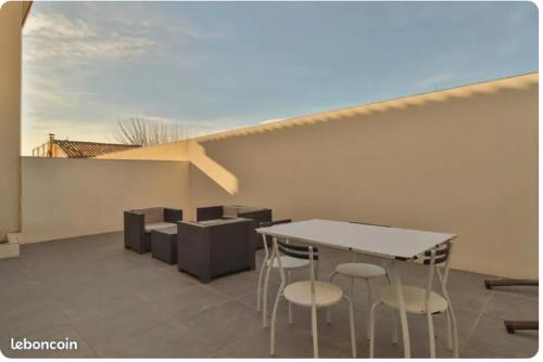 un patio avec une table et des chaises sur un toit dans l'établissement Maison de l’occitanie, à Bessan