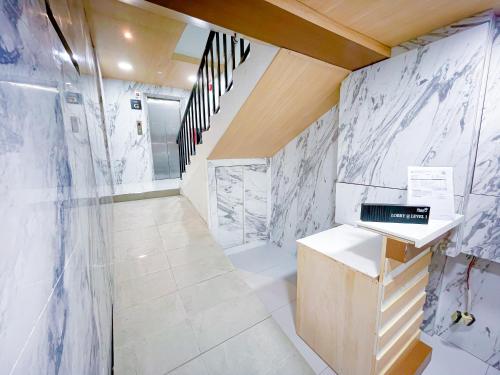 a bathroom with white marble walls and a staircase at StarQ Hotel Kuala Lumpur in Kuala Lumpur