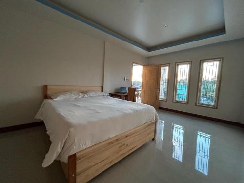 a bedroom with a large bed and windows at FOUR-G HOMESTAY & Komodo Tour in Labuan Bajo