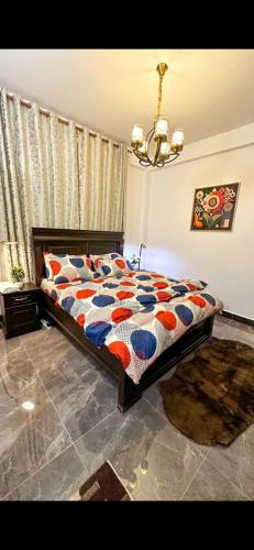 um quarto com uma cama com um edredão colorido em Bahama scape em Dar es Salaam