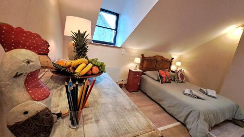 een kamer met een bed en een tafel met een fruitschaal bij COSY STUDIO-LOFT A SANCOINS in Sancoins
