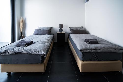 dos camas sentadas una al lado de la otra en un dormitorio en Blauer Stein Apartments Doppelzimmer 1, en Pulheim