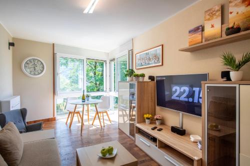 ein Wohnzimmer mit einem TV und einem Tisch in der Unterkunft Al Pontile Di Caslano - Happy Rentals in Caslano