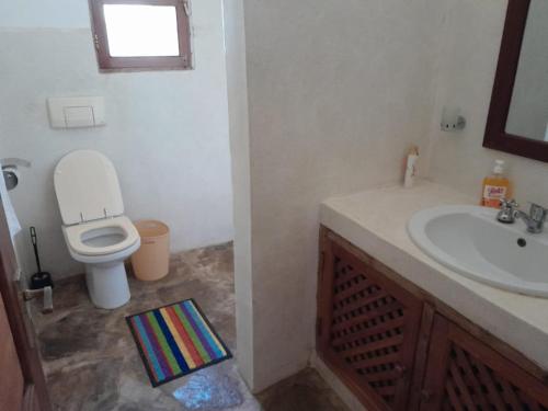 een badkamer met een toilet en een wastafel bij Lion Garden Villa 7 in Malindi