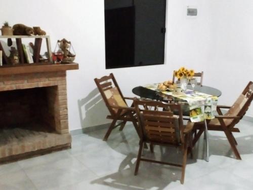 a dining room with a table and chairs and a fireplace at Casa de Amigos in Samaipata