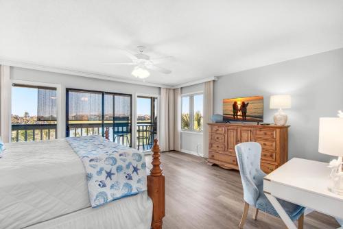 een slaapkamer met een bed, een bureau en ramen bij Seascape Lakefront Villas 281- Family Tides in Destin