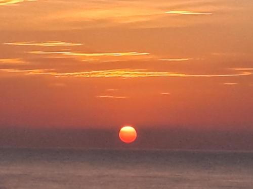 a sunset over the ocean with the sun in the sky at Attico fronte mare in Martinsicuro