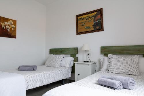 Habitación con 2 camas individuales y paredes blancas. en Apartamento Paraiso en Lanzarote en Caleta de Caballo