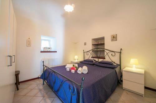 sypialnia z niebieskim łóżkiem z butami w obiekcie La Casa Sulla Roccia Trulli Pool - Happy Rentals w mieście Monopoli