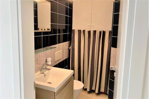 a small bathroom with a sink and a toilet at Attico Al Parco with airconditioning - Happy Rentals in Lugano