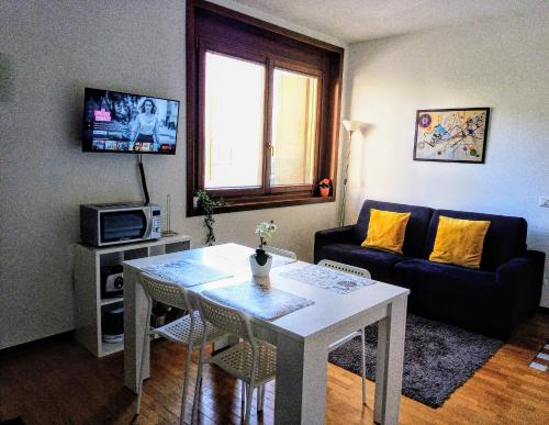 sala de estar con mesa y sofá en Mi casa es tu casa, en Pordenone