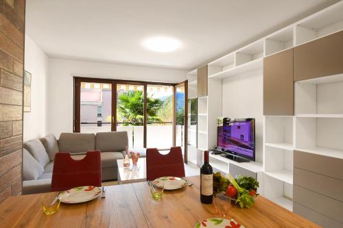 uma sala de estar com uma mesa e uma televisão em Casa Bruna Few Min From Lake - Happy Rentals em Caslano