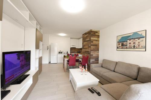 a living room with a couch and a flat screen tv at Casa Bruna Few Min From Lake - Happy Rentals in Caslano