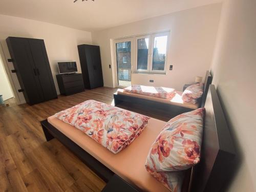 een kamer met 2 bedden met kussens erop bij Montihaus Gäste & Monteurzimmer in Dormagen