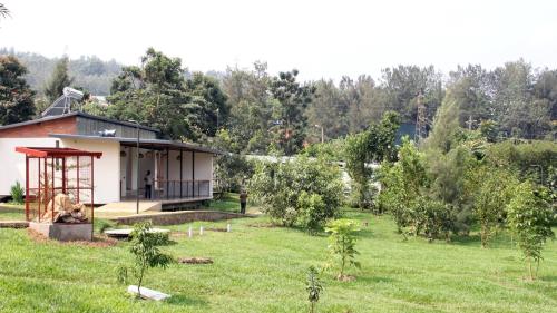 a house in a field with a yard with trees at DON BOSCO HOSPITALITY CENTRE KIGALI Ltd in Kigali