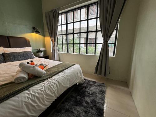 a bedroom with a bed with two stuffed animals on it at 85 Boutique Hotel in Ipoh
