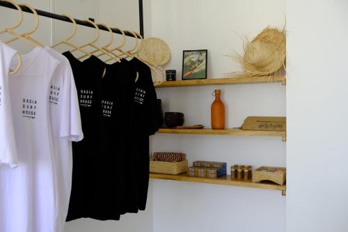 un armario con un vestido negro y estanterías en OASIA - Boutique Surf House (ADULTS ONLY) en Weligama